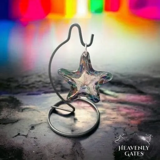 A small iridescent glass star hanging from a curled metal stand.