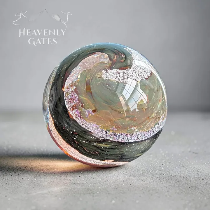 A round glass orb swirled with dark green, rose and sparkling white.