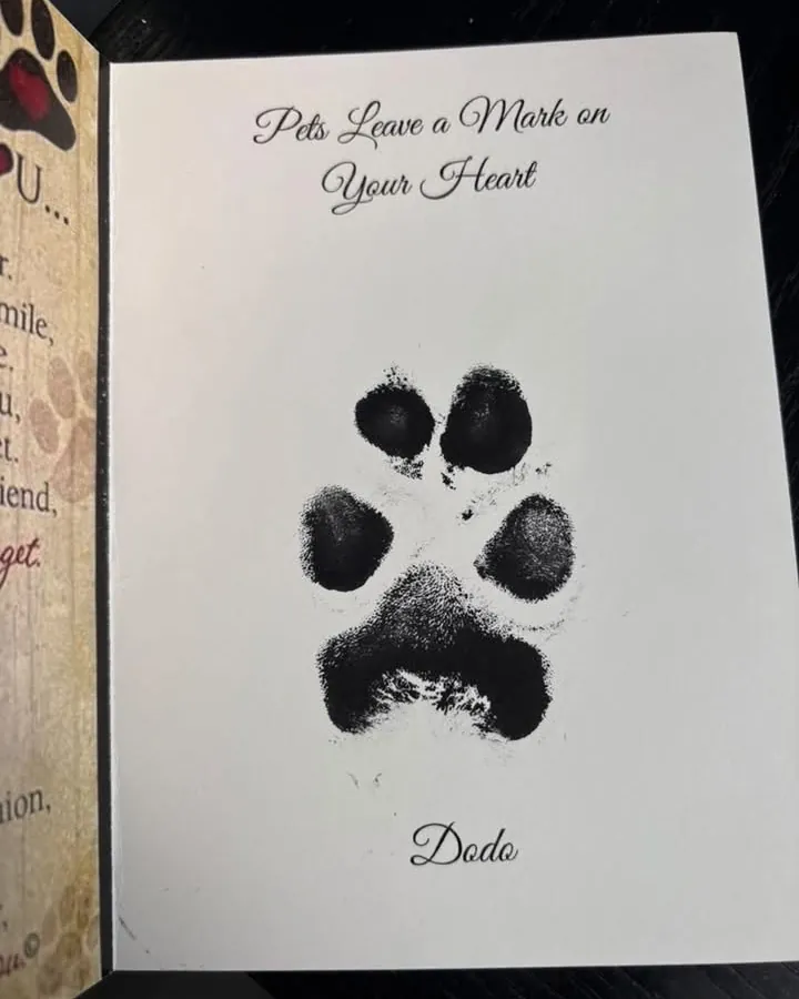 An open ink paw print card titled Pets Leave a Mark on Your Heart, with a paw print and the name Dodo.