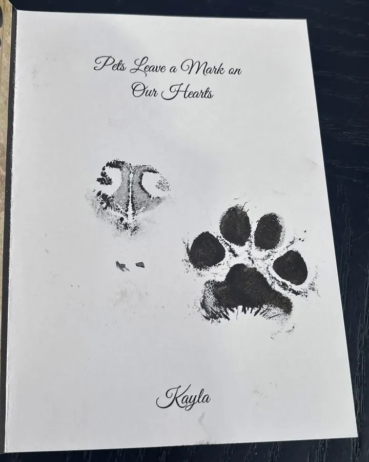 An open ink paw print card titled Pets Leave a Mark on Our Hearts, with a nose print, a paw print and the name Kayla.
