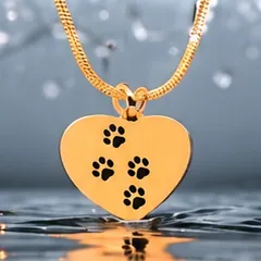 A gold heart pendant with three black paw prints.