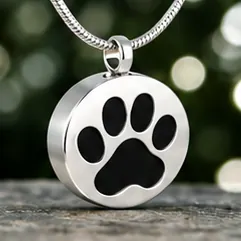 A round silver pendant with a large black paw print.
