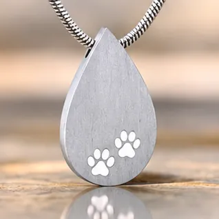 A brushed silver teardrop pendant with two cut-out paw prints.