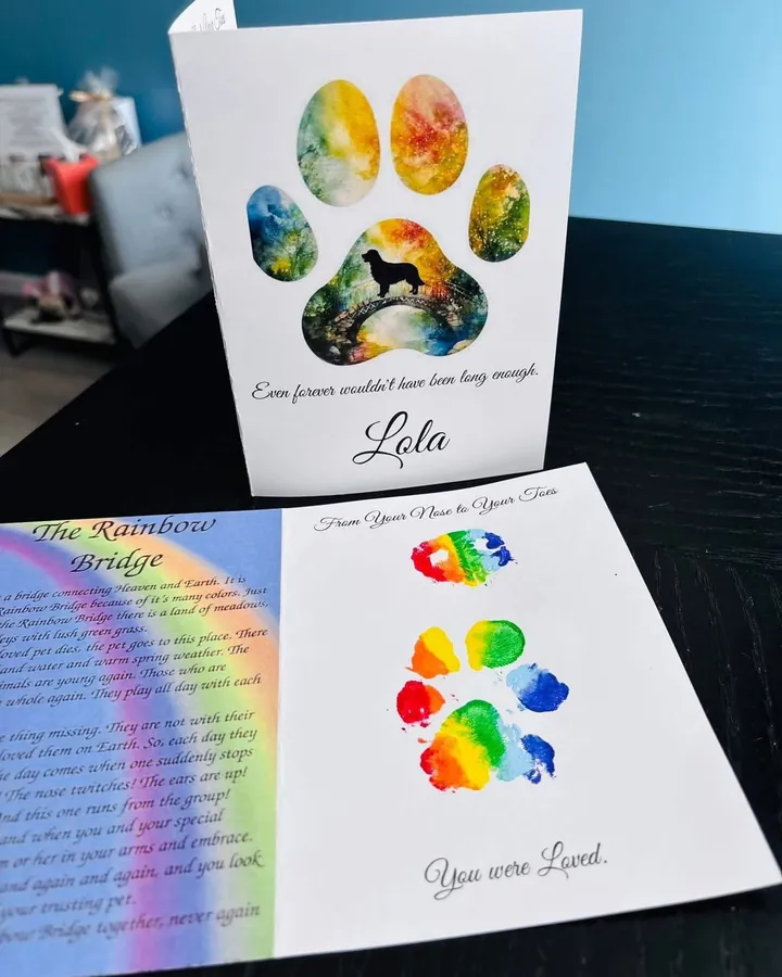Two Rainbow Bridge paw print cards: a watercolor paw framing a dog on a bridge above the name Lola, and rainbow paw and nose prints beside the Rainbow Bridge poem.
